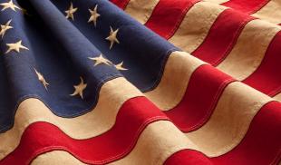 An old, rippling thirteen-starred American flag.