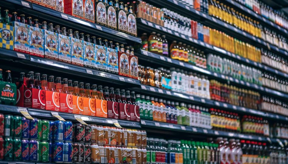 Wall of soft drinks displayed on supermarket shelves