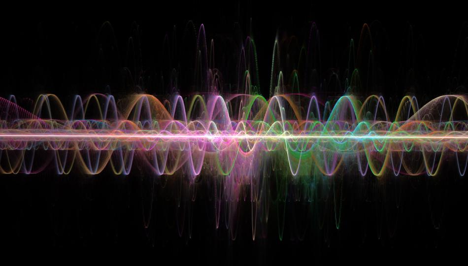 Digitally generated waves in a spectrum of vivid colors set against a black backdrop