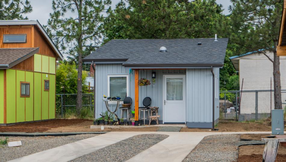 A small village of tiny houses, with a small grey-blue house in the center.