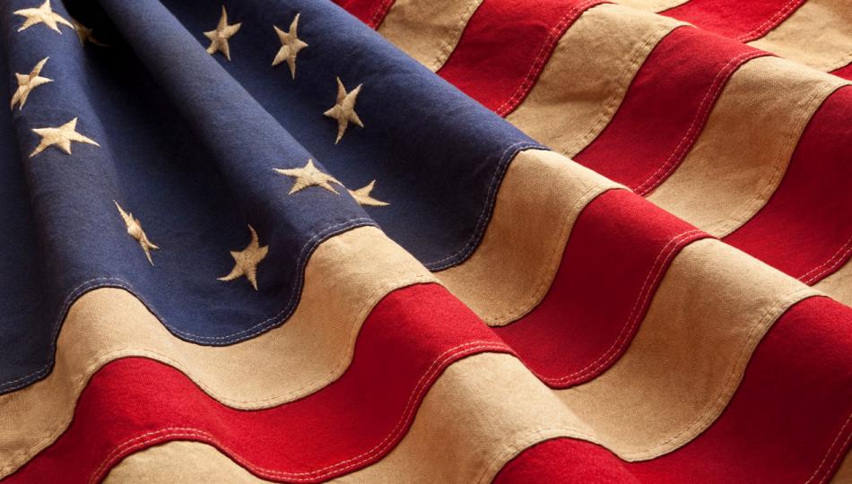 An old, rippling thirteen-starred American flag.