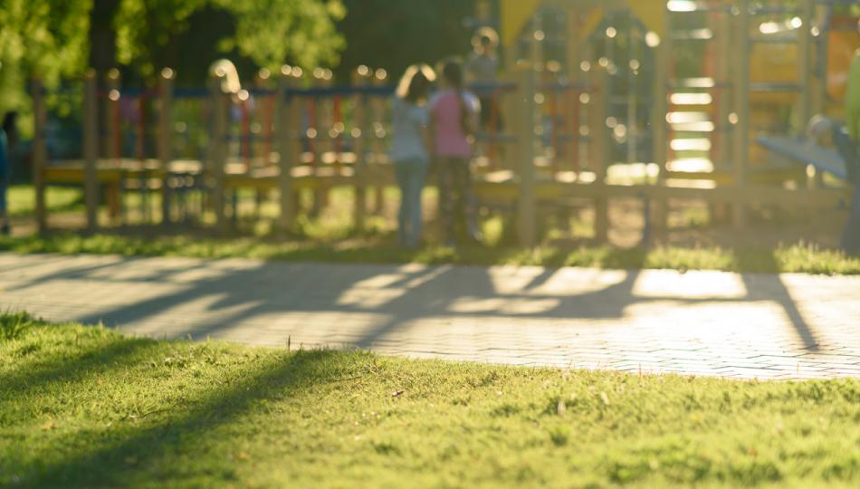 A soft focused image of children on a playground in a public park.