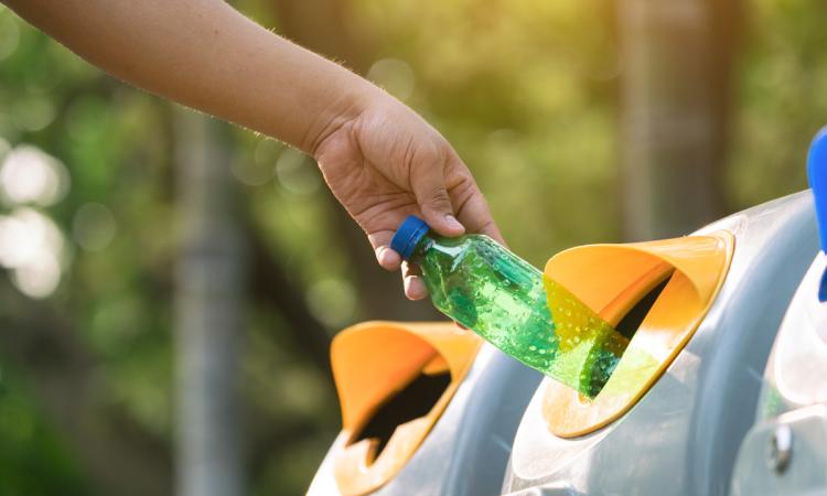 A water bottle is recycled in the proper place.