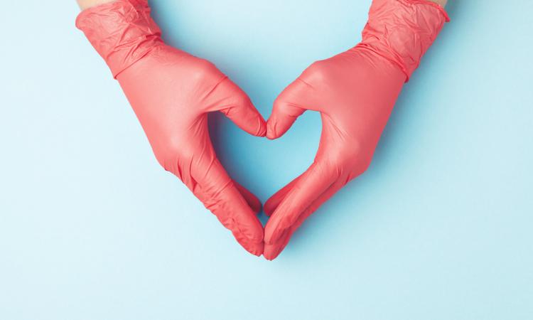 two hands in latex gloves forming the shape of a heart