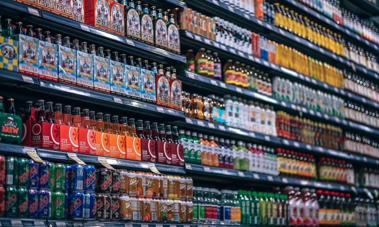 Wall of soft drinks displayed on supermarket shelves