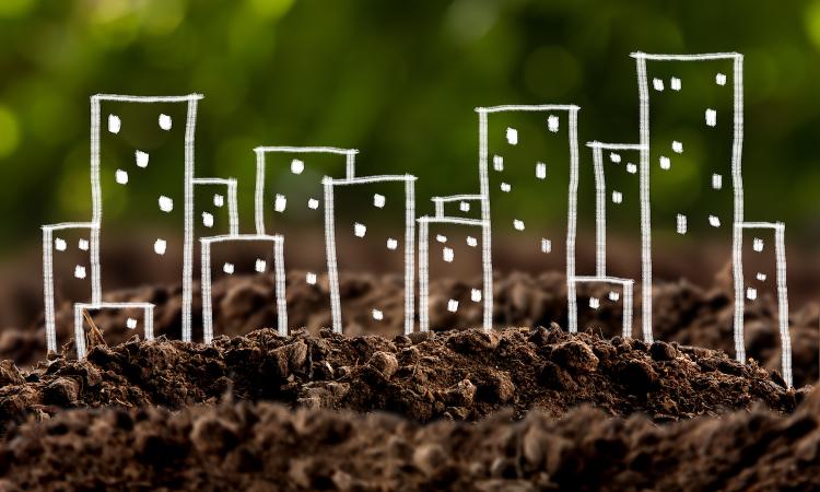 Conceptual image showing chalk drawings of cityscape growing out of the ground