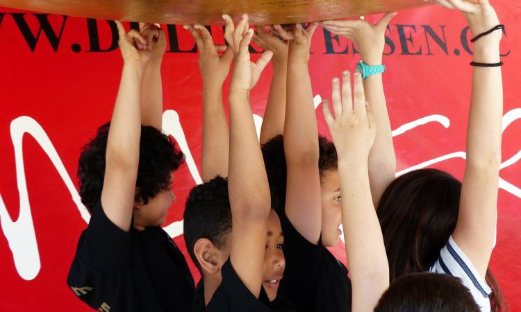 Image of children holding up a huge sphere